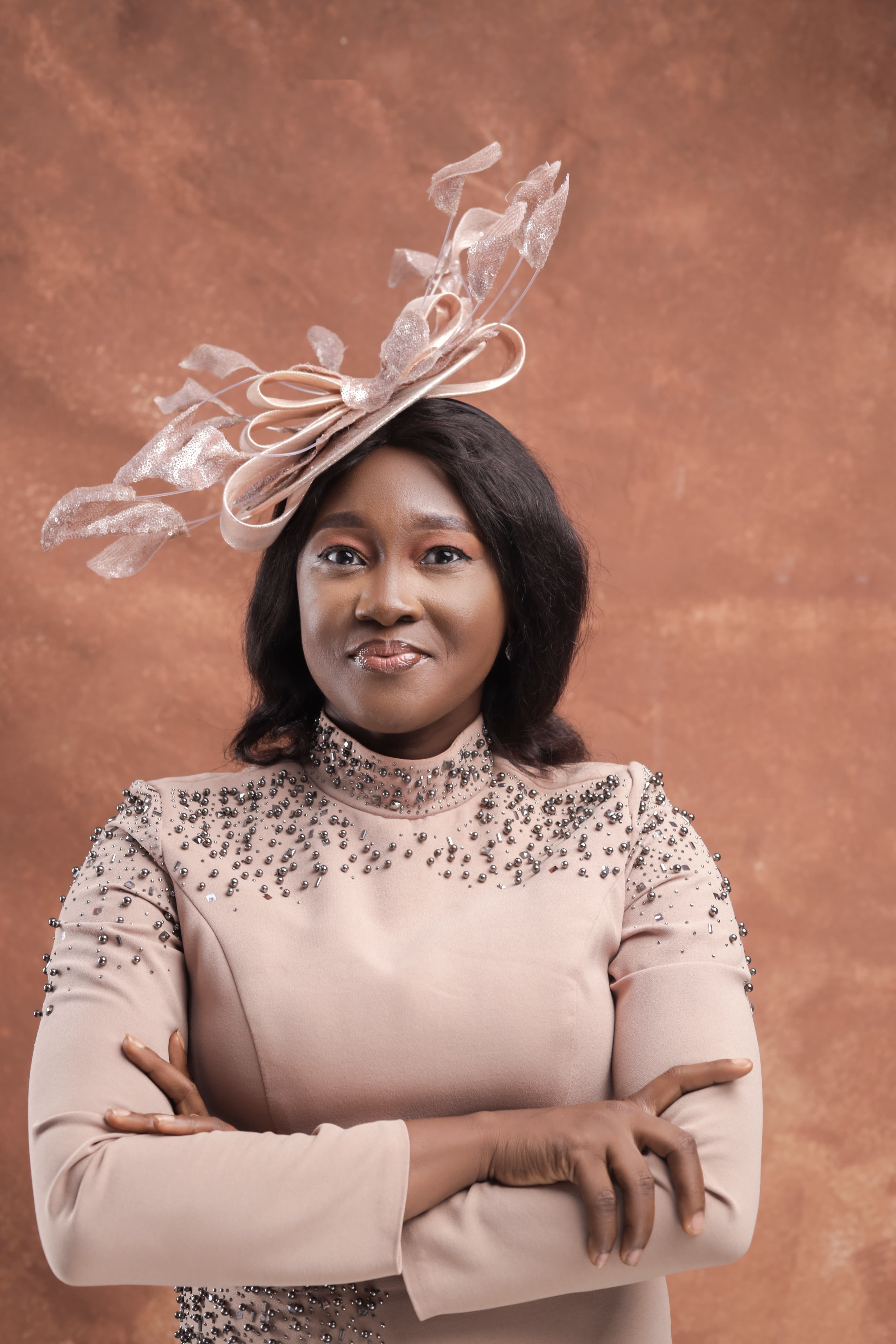 Boluwaduro Adeseko in a beaded blush gown and fascinator