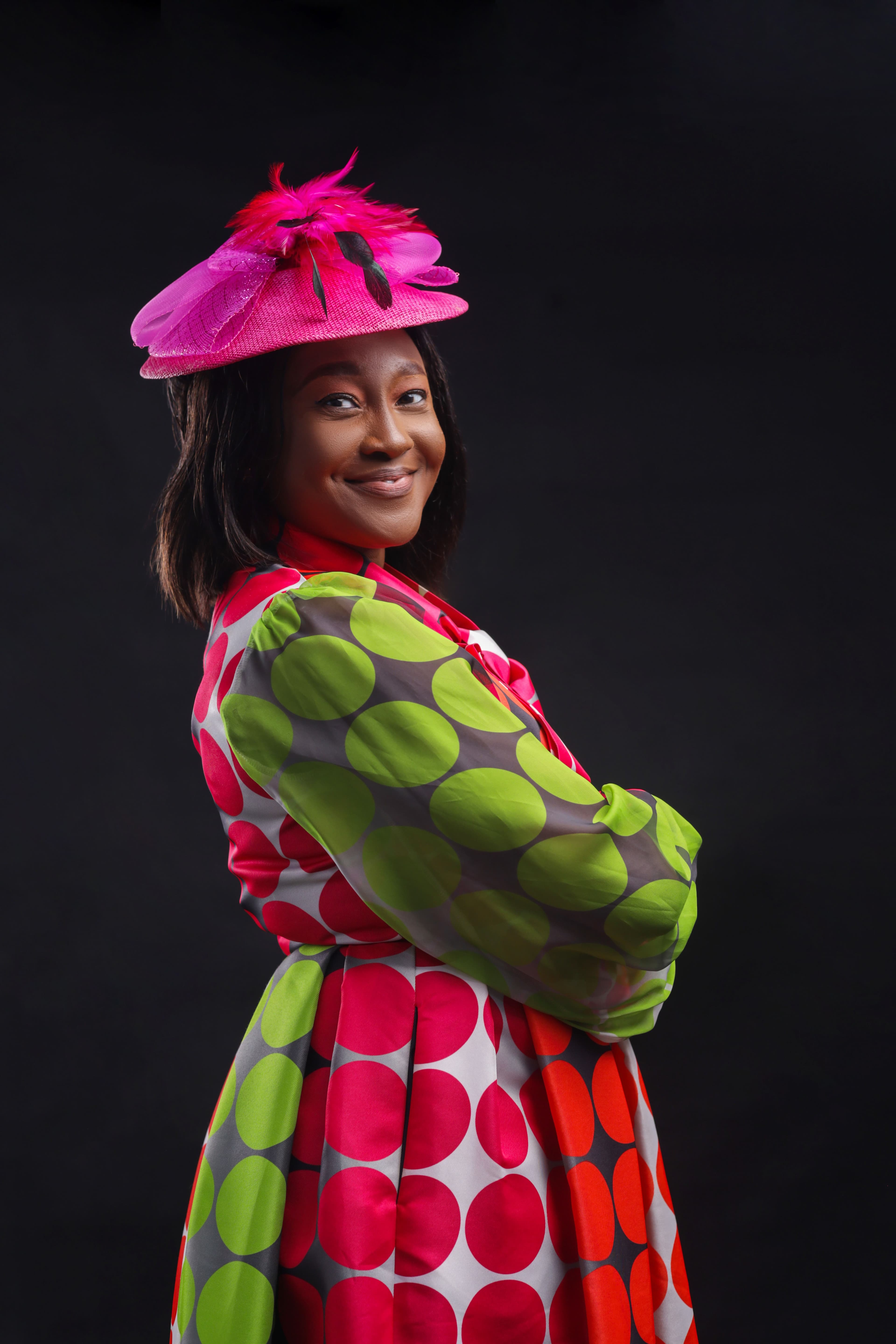 Boluwaduro Adeseko in a vibrant printed dress and hat